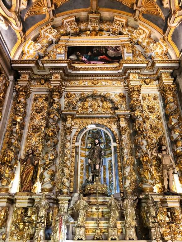 The ornate decoration of the chapels inside Igreja de São Roque, with intricate details and gilded altarpieces.