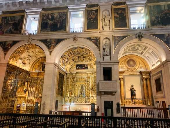 Frescoed ceilings and gilded altarpieces inside the chapels of Igreja de São Roque, showcasing the Baroque architecture.