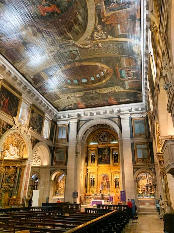 A close up of the frescoed ceilings and gilded altarpieces inside one of the chapels of Igreja de São Roque, showcasing the artistic masterpiece of the Baroque architecture.
