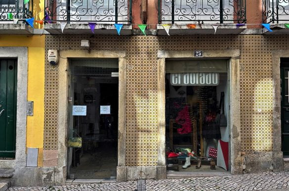 Exterior view of a quaint vintage shop located on a cobblestone street in Lisbon.