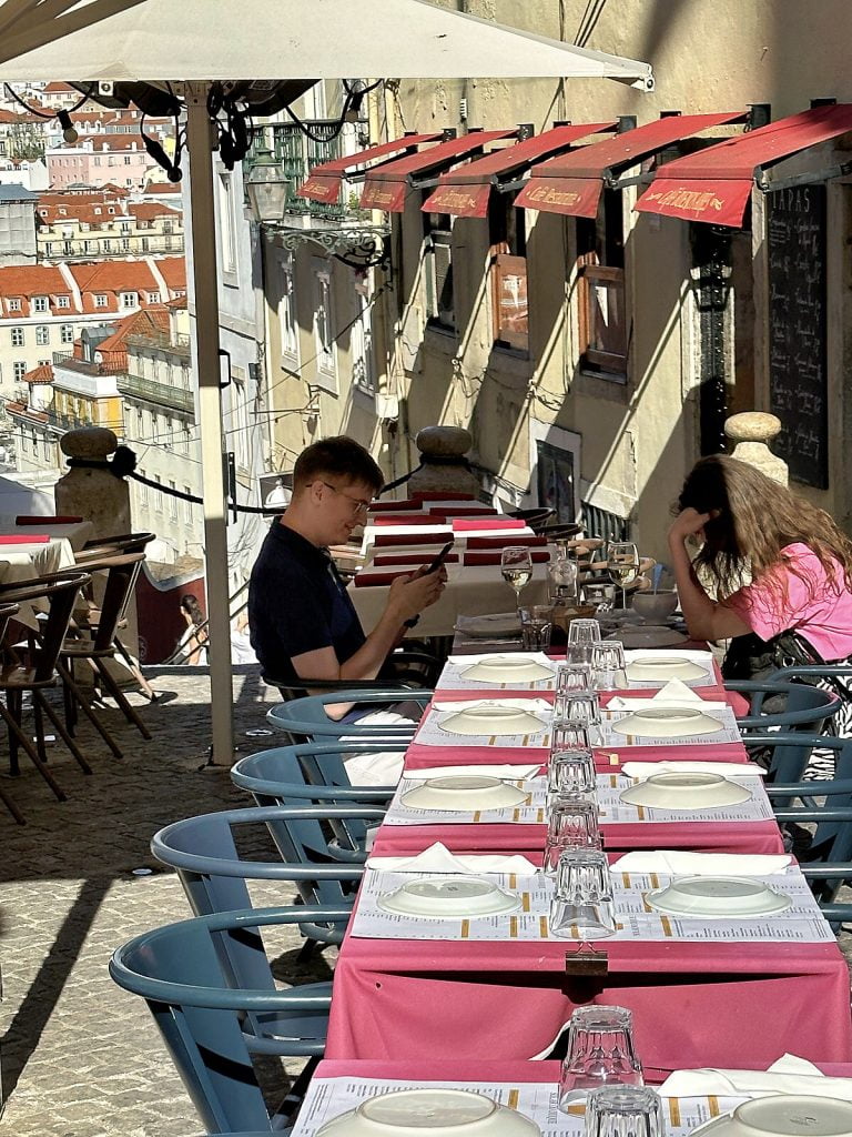 Outdoor dining setting with a sweeping view of Lisbon's skyline.